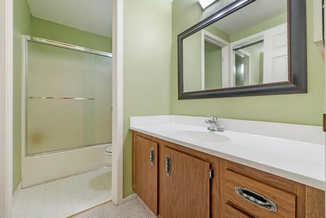 a bathroom with a granite countertop sink and mirror
