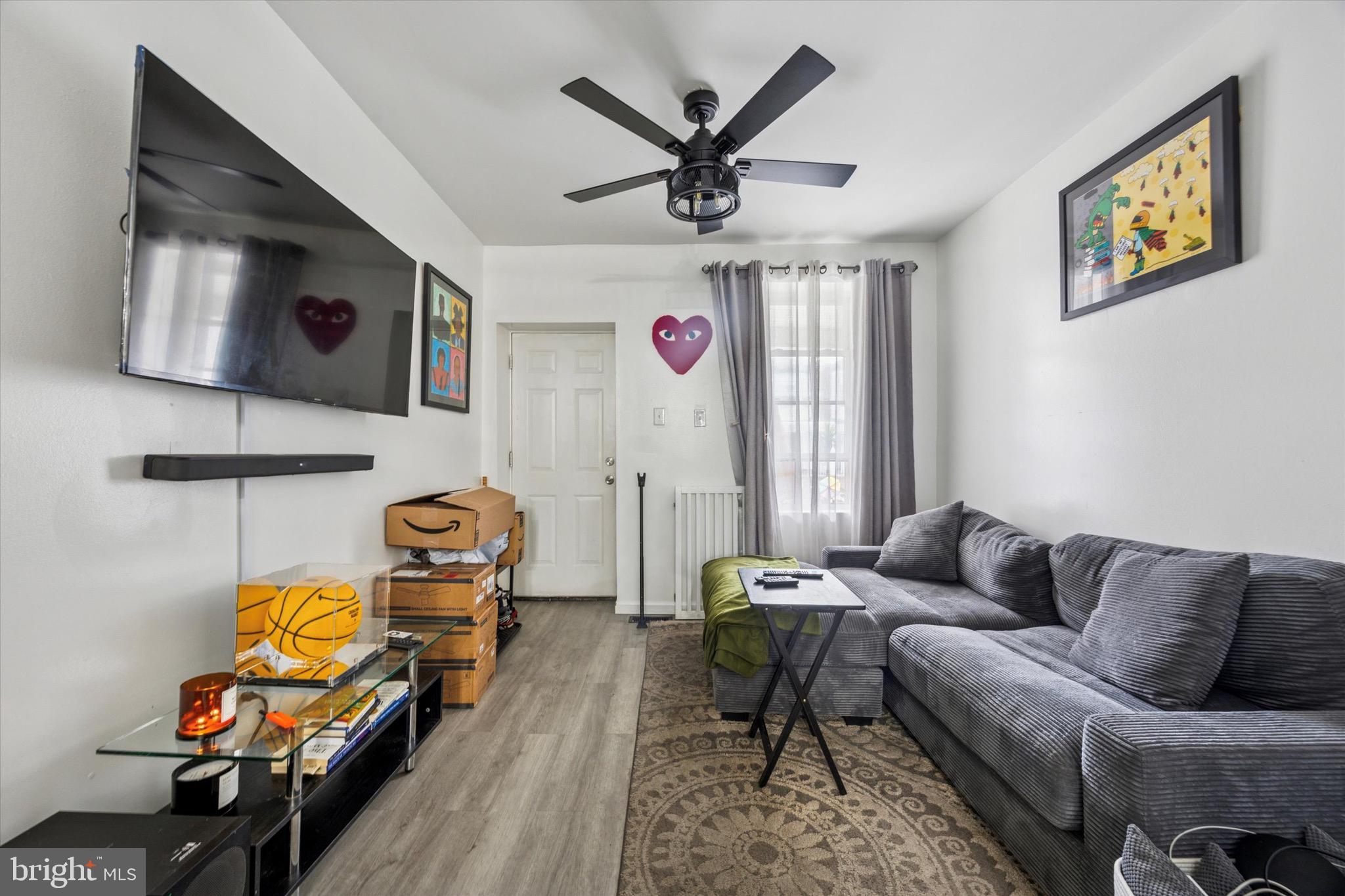 6153 Locust Street, Unit 1 Philadelphia, PA 19139 - Photo 3 of 14 a living room with furniture a rug and a chandelier