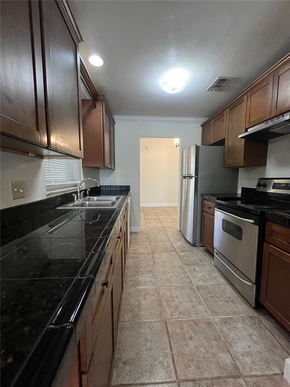3222 Hammersmith Road Orlando, FL 32818 - Photo 7 of 29 a kitchen with granite countertop a stove and a refrigerator