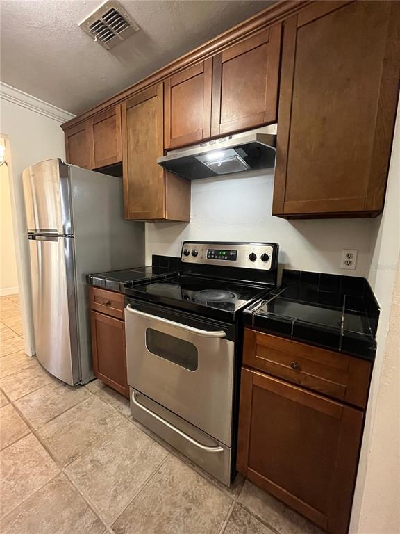 3222 Hammersmith Road Orlando, FL 32818 - Photo 9 of 29 a kitchen with stainless steel appliances granite countertop a refrigerator a stove and a sink