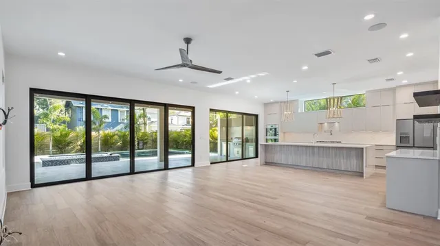 a large white kitchen with a large window and stainless steel appliances