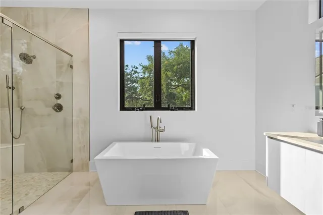 a white bath tub sitting next to a shower