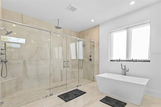 a bathroom with a bathtub a window and a shower