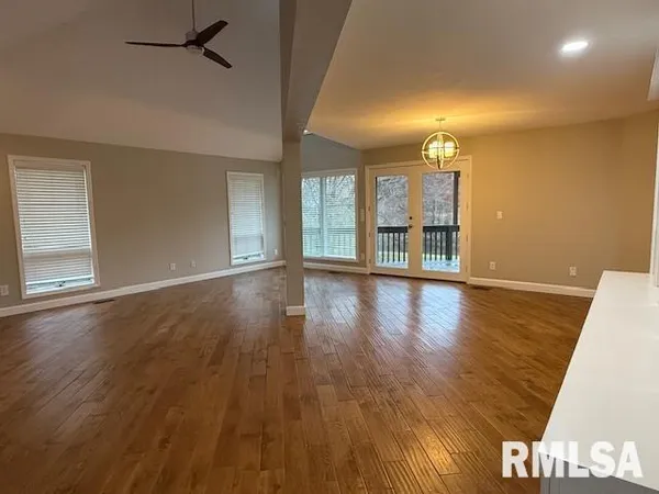 a view of a livingroom with wooden floor and a ceiling fan