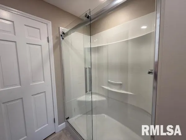 a bathroom with a sink mirror and shower