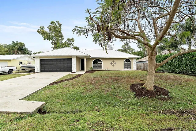 a front view of a house with a garden