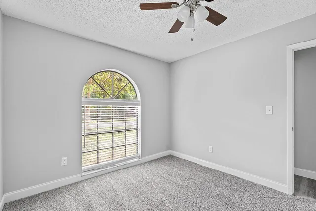 an empty room with a window and a chandelier