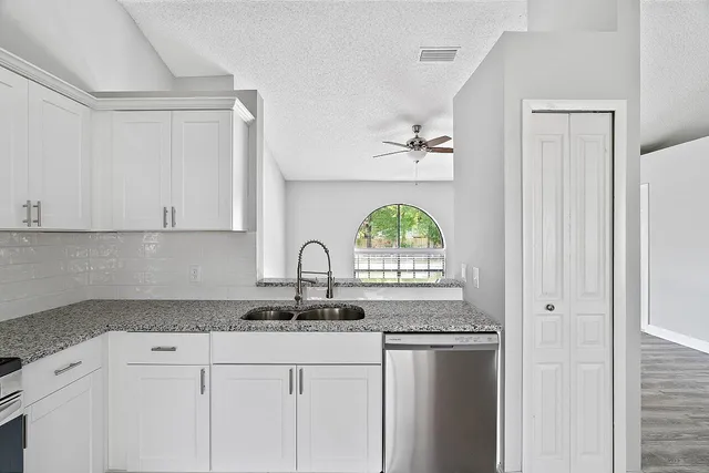 a kitchen with stainless steel appliances granite countertop a sink a stove and a refrigerator