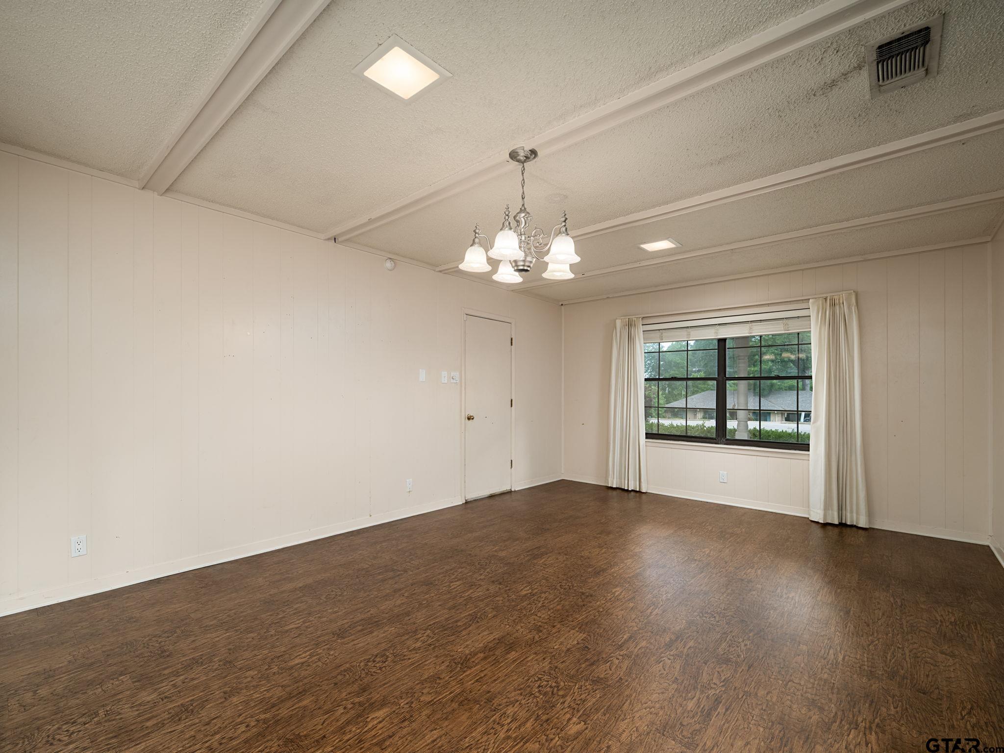 2513 Merry Lane Tyler, TX 75701 - Photo 12 of 26 an empty room with wooden floor chandelier and windows