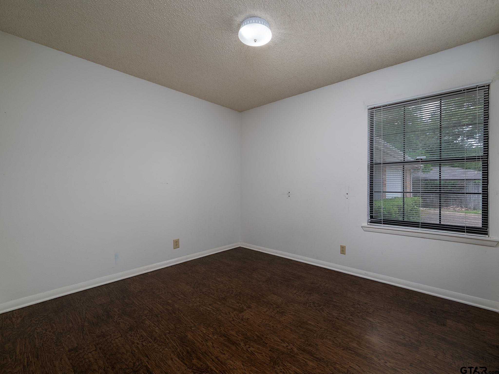 2513 Merry Lane Tyler, TX 75701 - Photo 16 of 26 an empty room with wooden floor and windows