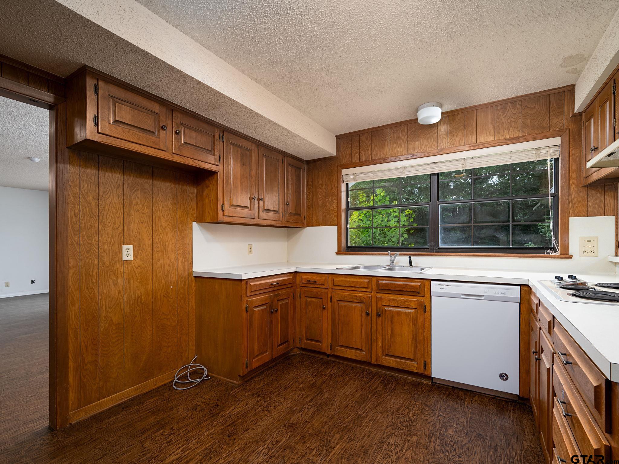2513 Merry Lane Tyler, TX 75701 - Photo 8 of 26 a kitchen with stainless steel appliances granite countertop wooden cabinets a sink and a window