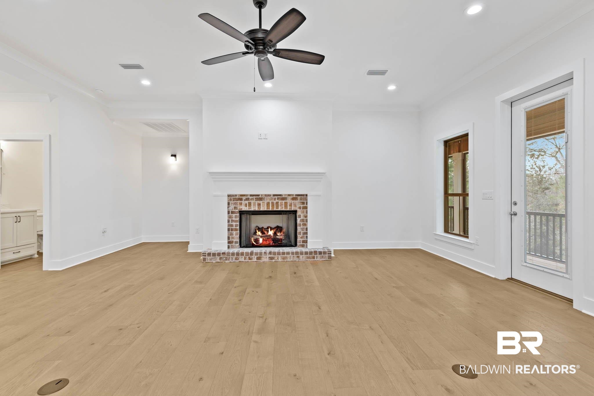 6656 Garrison Drive Daphne, AL 36527 - Photo 20 of 57 Unfurnished living room featuring light wood-style floors, ornamental molding, a brick fireplace, a ceiling fan, and recessed lighting