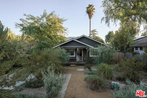 a front view of a house with yard and green space