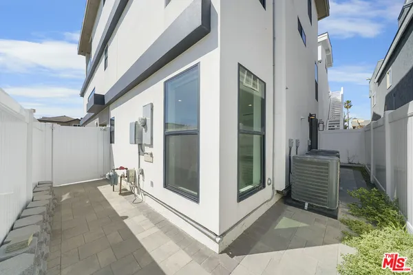 a living room with stainless steel appliances kitchen island granite countertop a sink and a large window