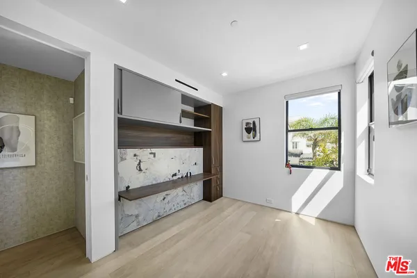 a spacious bedroom with a bed and wooden floor