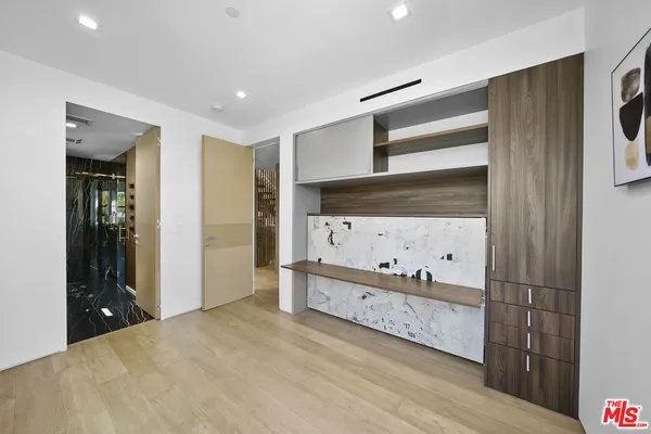 a bedroom with a bed a flat screen tv and a large window