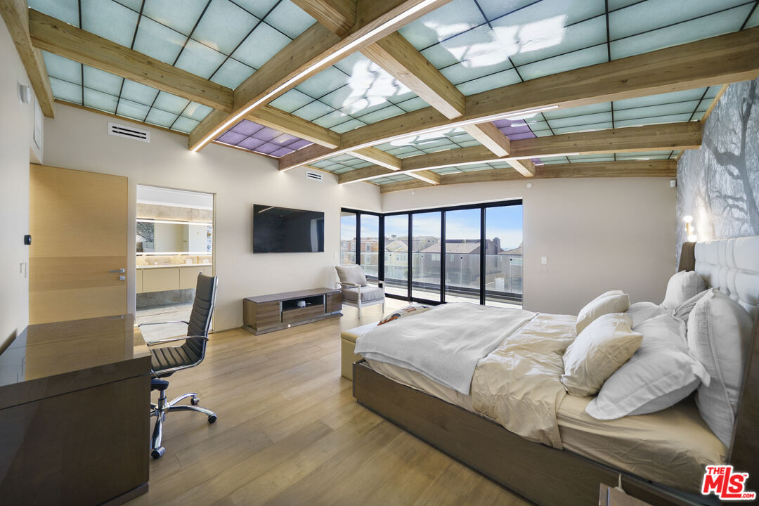 1500 Ocean Drive Oxnard, CA 93035 - Photo 53 of 75 a bedroom with a bed a flat screen tv and a large window