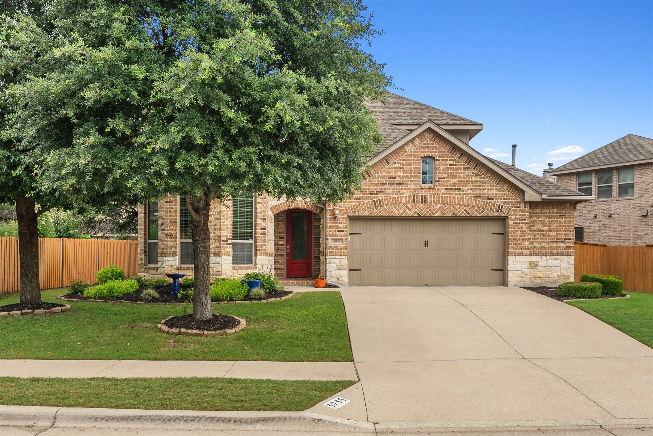 Welcome to this Ranch at Brushy Creek home, where a butterfly-friendly front garden greets you with vibrant life and color