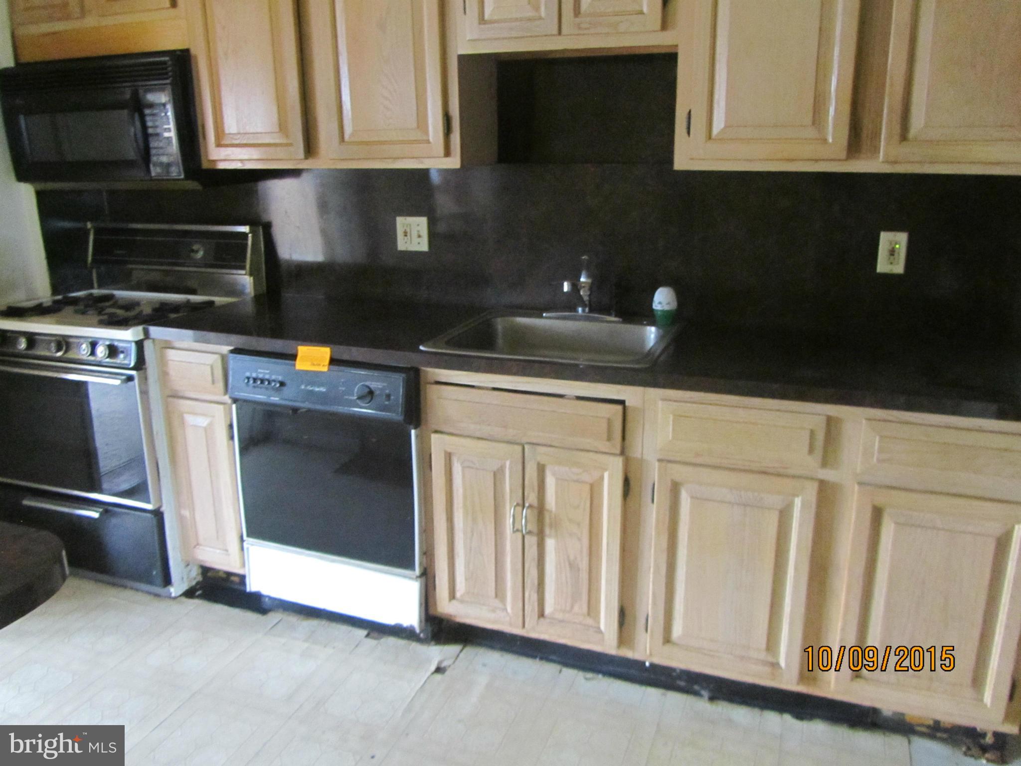 3227 Vulcan Road Baltimore, MD 21222 - Photo 10 of 17 a kitchen with granite countertop white cabinets stainless steel appliances and wooden floor