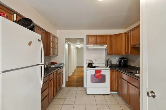a kitchen with a refrigerator a stove top oven a sink and cabinets