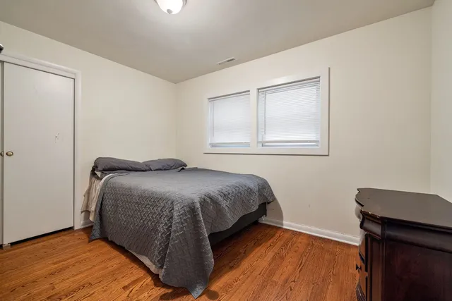 a bedroom with a bed and wooden floor
