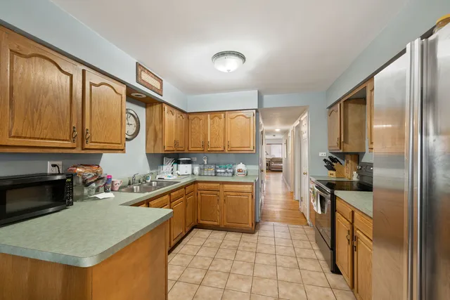 a kitchen with stainless steel appliances granite countertop a stove a sink a refrigerator and cabinets