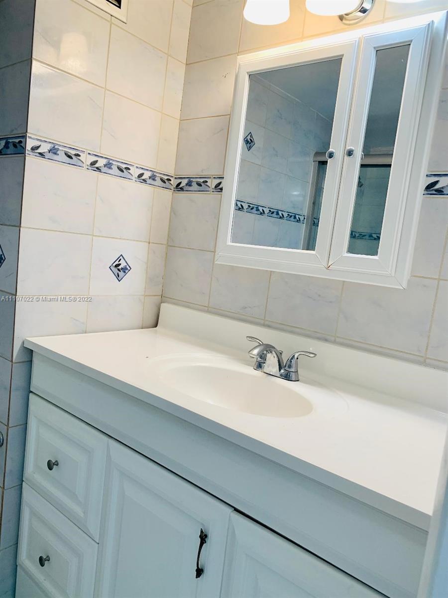 8001 Crespi Boulevard, Unit 2D Miami Beach, FL 33141 - Photo 8 of 12 a bathroom with a sink and a mirror