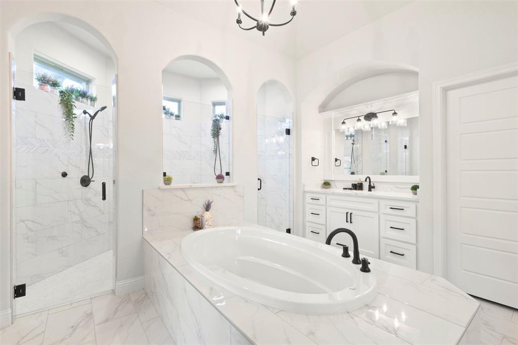 105 Clayton Crossing Springtown, TX 76082 - Photo 15 of 40 a bathroom with a sink a mirror a bathtub and shower