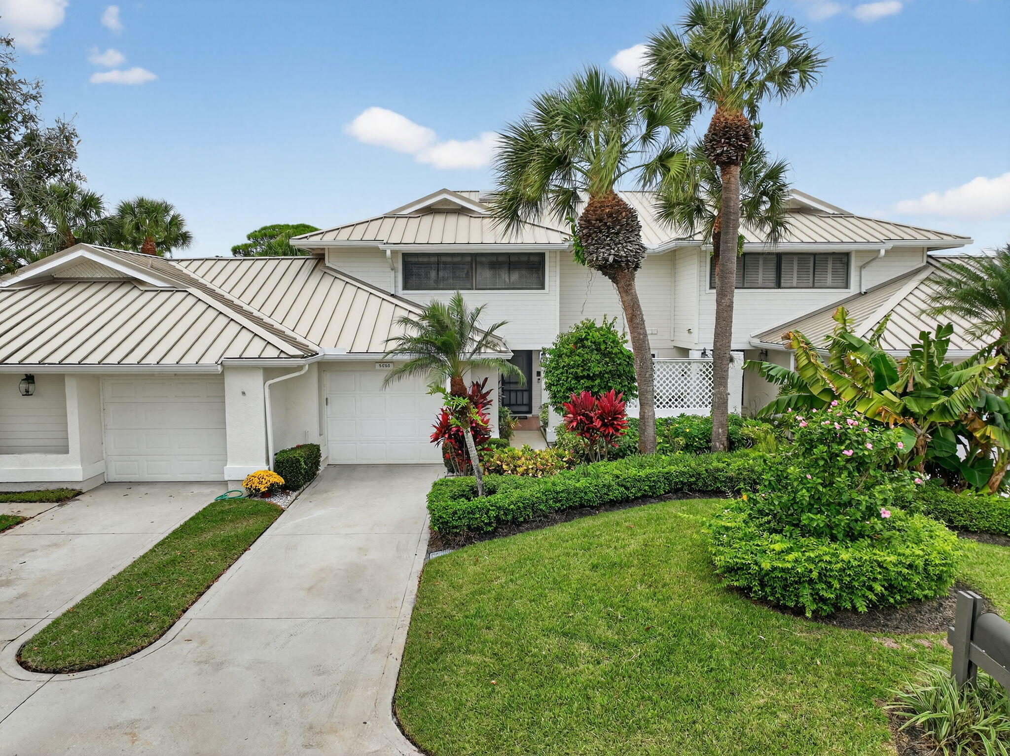 a front view of a house with a garden and plants