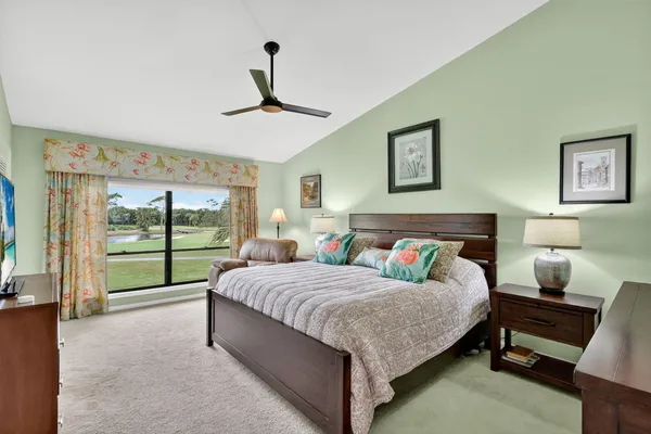 a bedroom with a bed couches and paintings on the wall