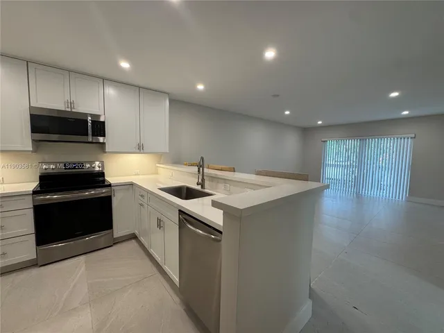 a kitchen with a sink a stove and microwave
