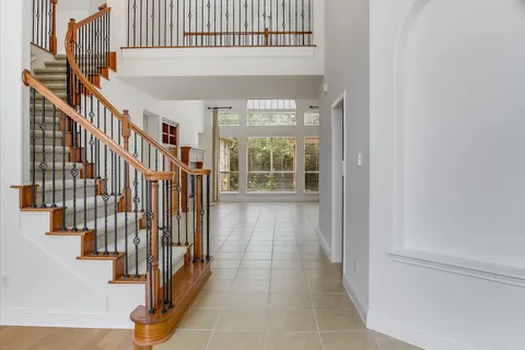 a hallway with wooden floor and windows