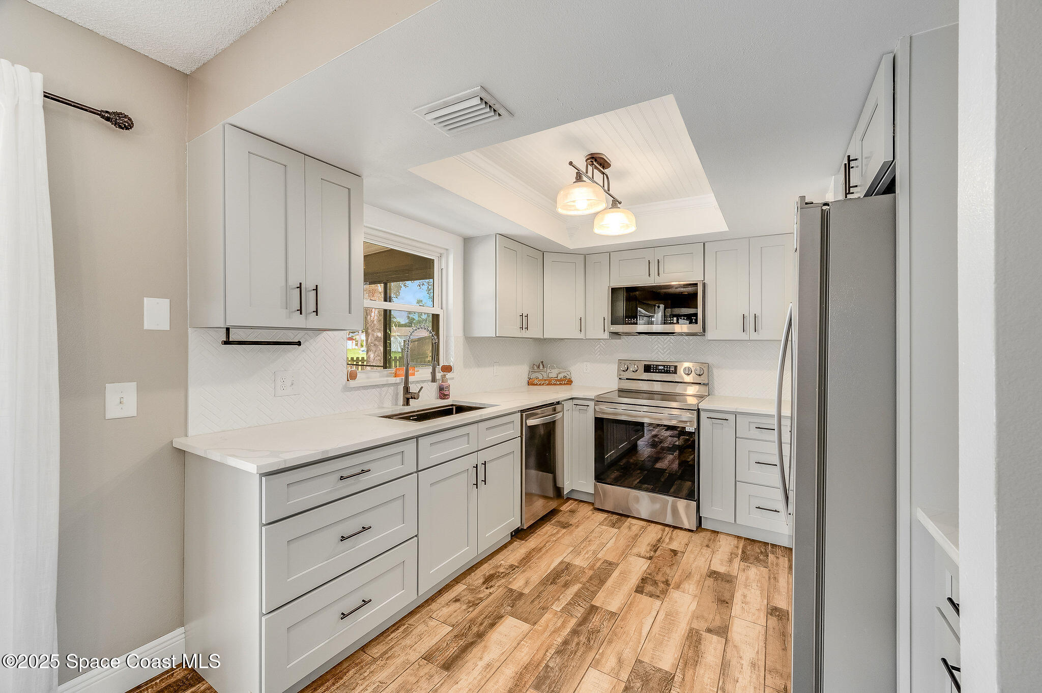 3816 Parapet Drive Cocoa, FL 32926 - Photo 11 of 32 a kitchen with stainless steel appliances a stove refrigerator and microwave