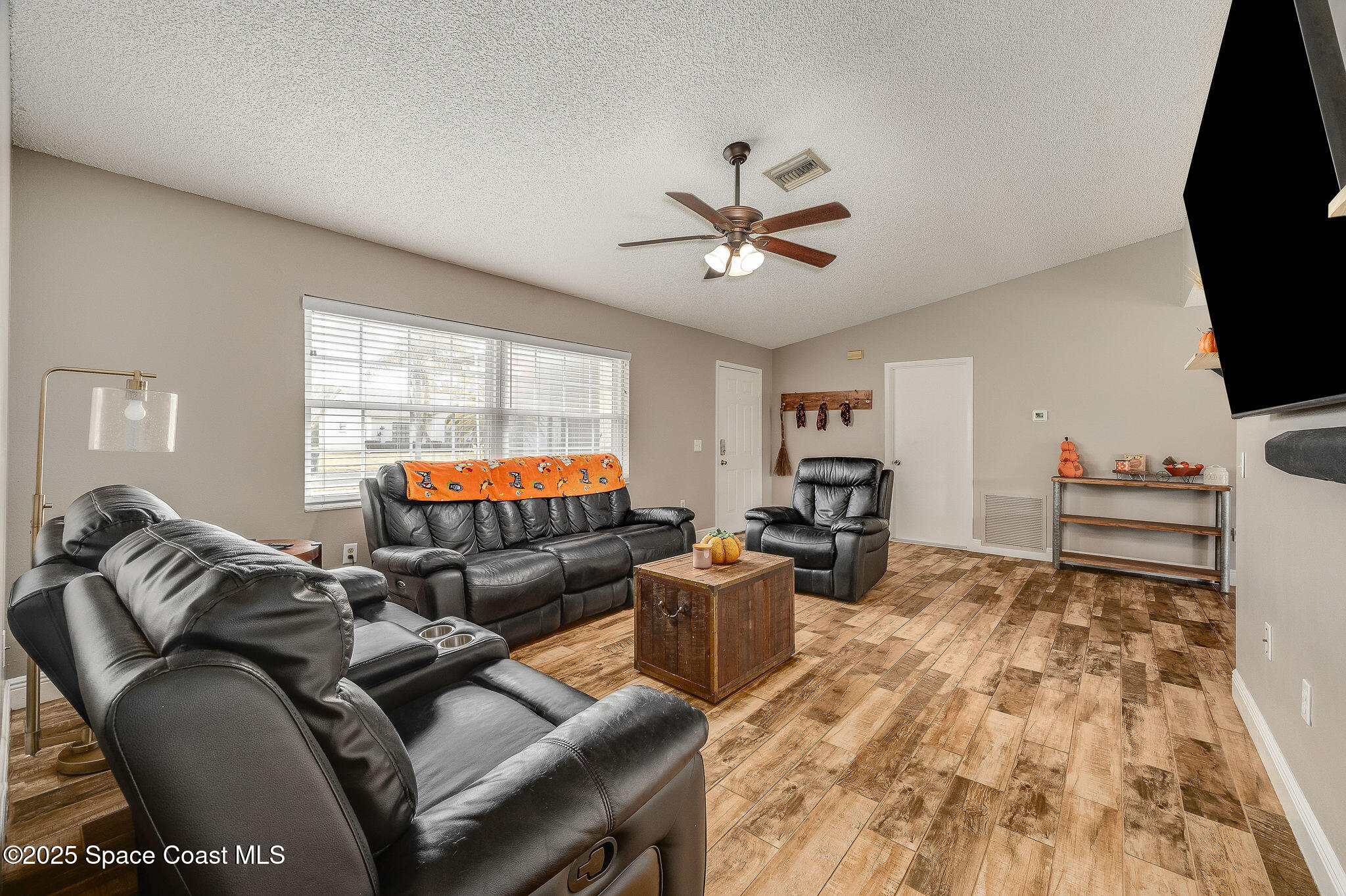 3816 Parapet Drive Cocoa, FL 32926 - Photo 14 of 32 a living room with furniture a flat screen tv and wooden floor