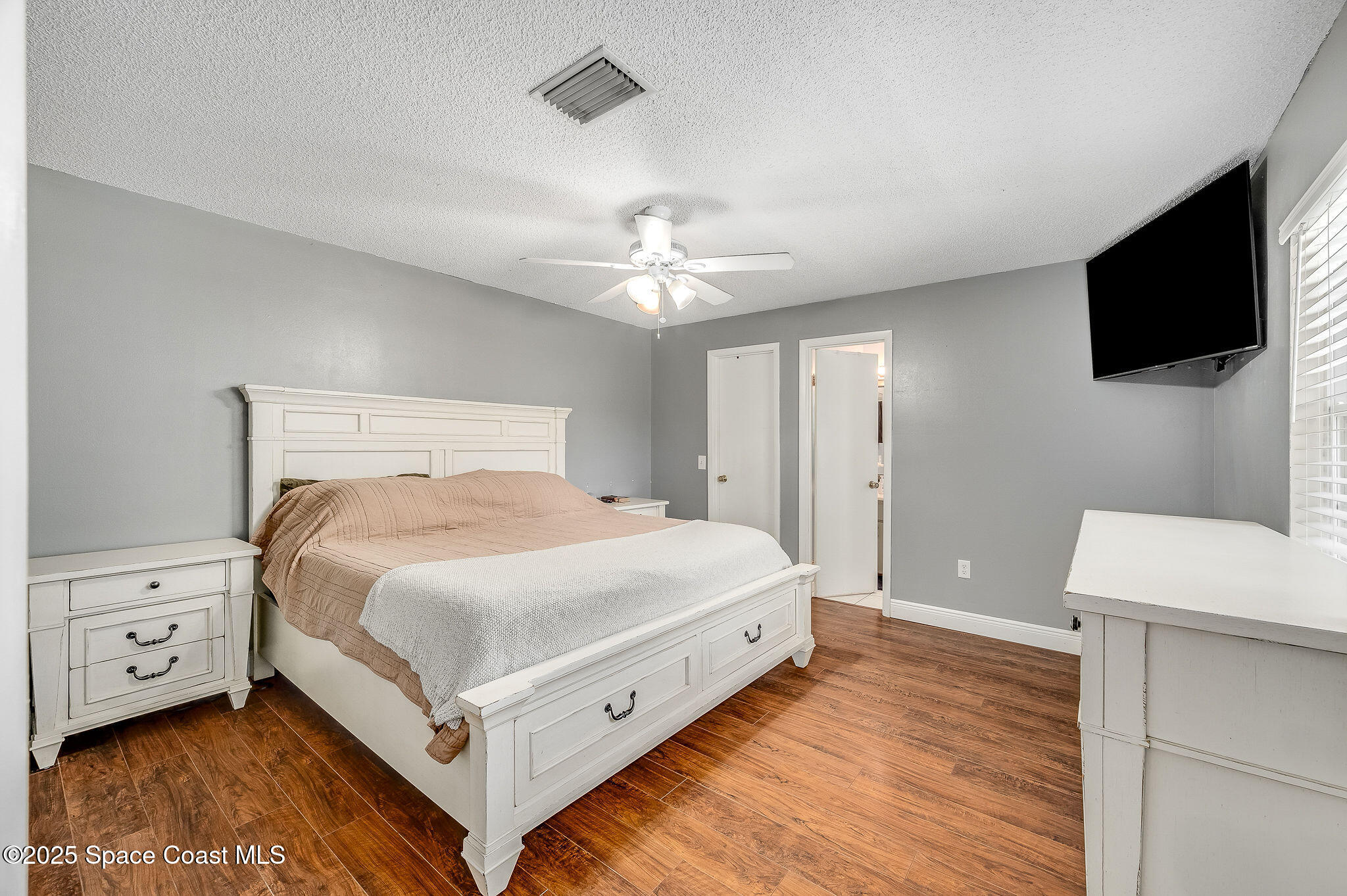 3816 Parapet Drive Cocoa, FL 32926 - Photo 21 of 32 a bedroom with a bed and a flat tv screen on dresser