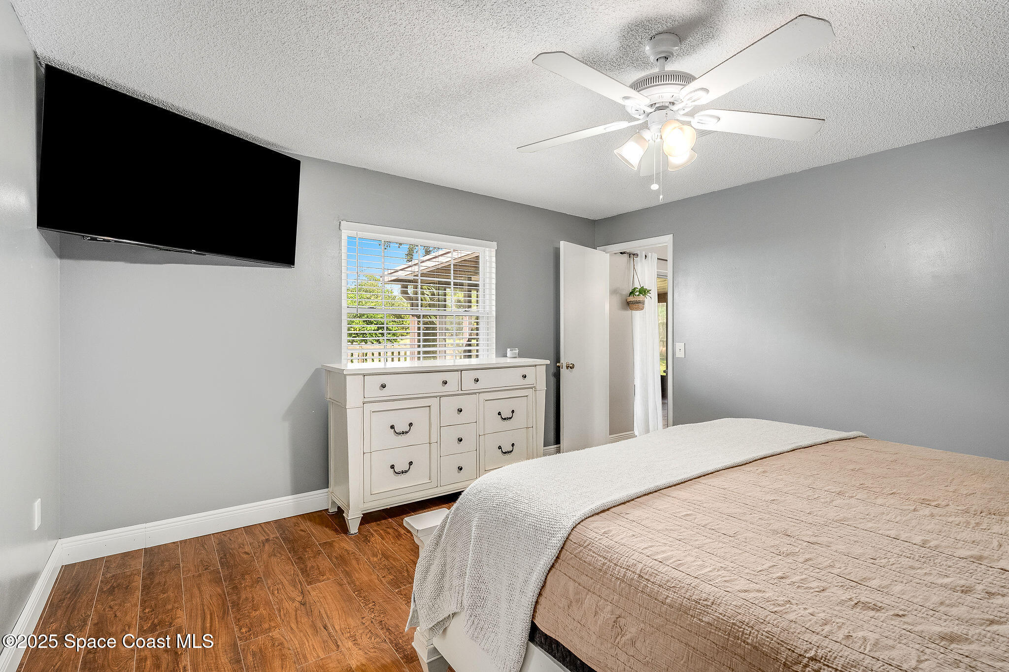3816 Parapet Drive Cocoa, FL 32926 - Photo 22 of 32 a bedroom with a bed a window and a flat screen tv