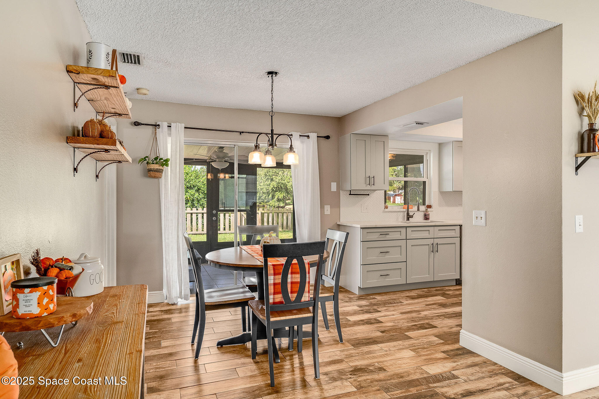 3816 Parapet Drive Cocoa, FL 32926 - Photo 8 of 32 a dining room with furniture a chandelier and wooden floor