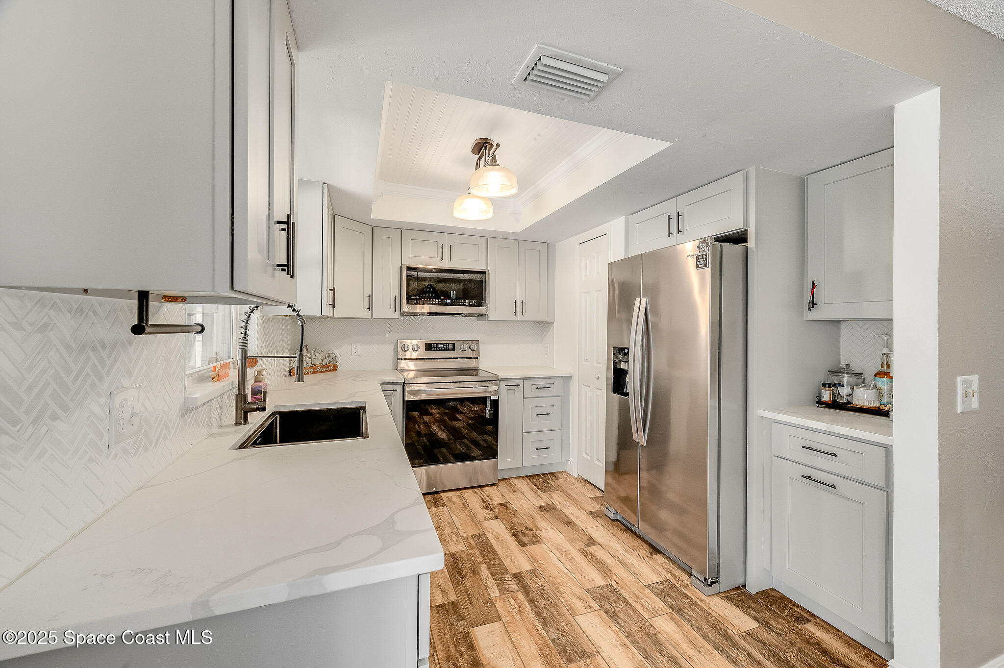 3816 Parapet Drive Cocoa, FL 32926 - Photo 10 of 32 a kitchen with stainless steel appliances a stove refrigerator sink and microwave