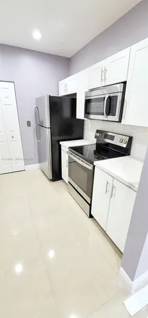 a kitchen with stainless steel appliances a stove a microwave and a refrigerator