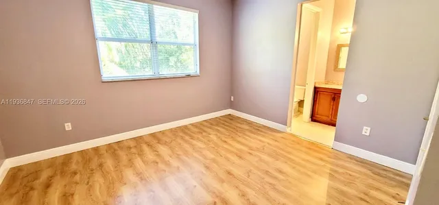 a view of a bedroom with wooden floor