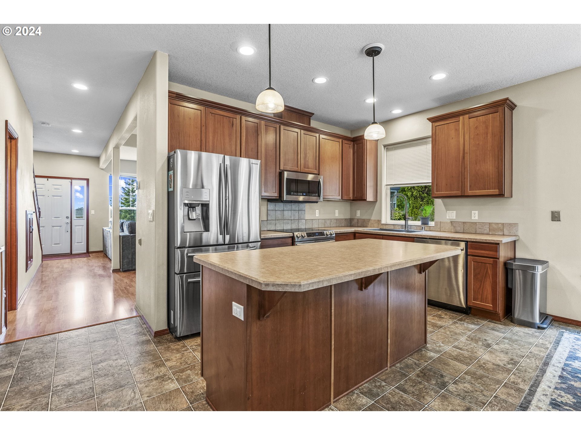 145 Ruby Court Kelso, WA 98626 - Photo 10 of 35 a kitchen with kitchen island granite countertop a sink refrigerator and cabinets