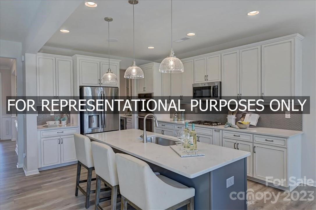 4184 Charlton Road, Unit 203 Fort Mill, SC 29715 - Photo 8 of 22 a kitchen with a table chairs microwave and cabinets