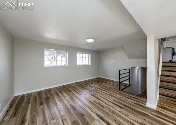 a view of empty room with wooden floor