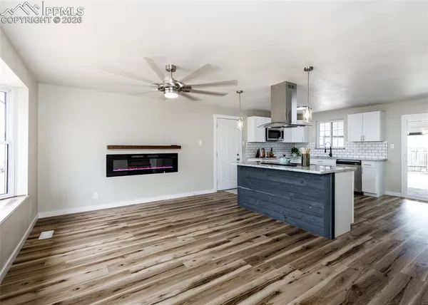 a kitchen with stainless steel appliances kitchen island granite countertop a stove top oven a sink and a counter space