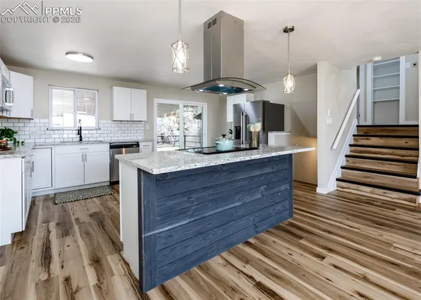 a kitchen with granite countertop wooden cabinets and white appliances