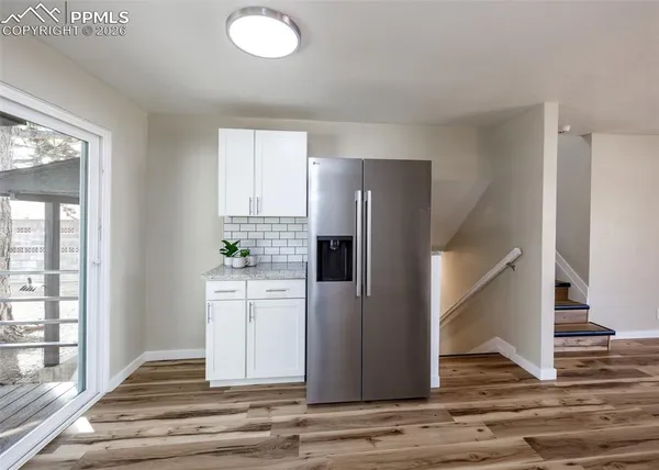 a view of a kitchen with wooden floor and staircase