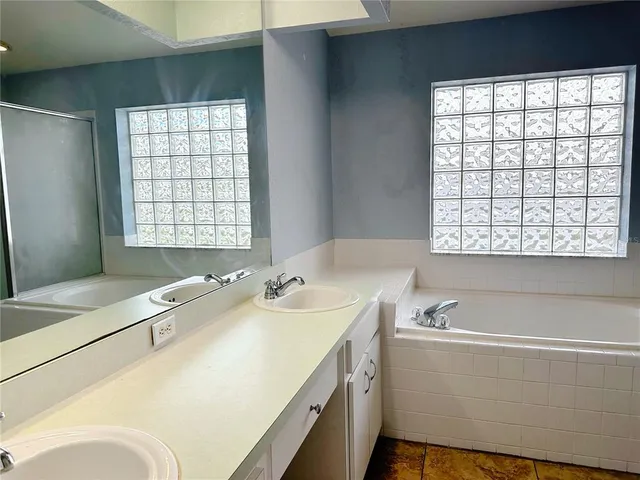 a bathroom with a granite countertop sink and a bathtub