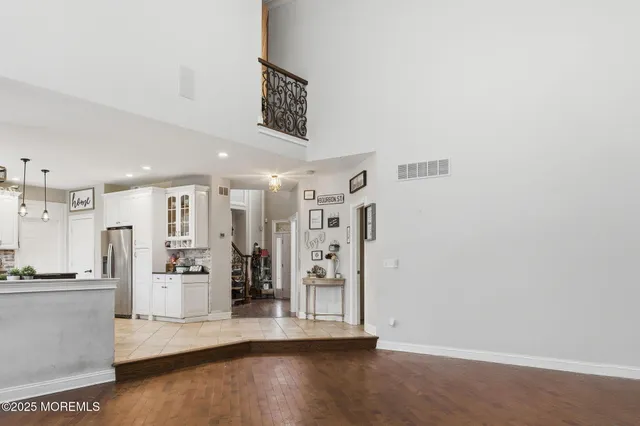 a view of a kitchen with refrigerator and wooden floor