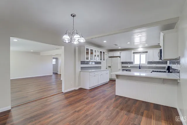 a kitchen with stainless steel appliances granite countertop a sink cabinets and wooden floor