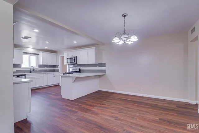 a view of kitchen with wooden floor and stainless steel appliances